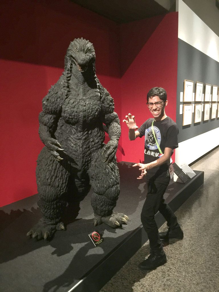 Sean posing in front of Godzilla costume